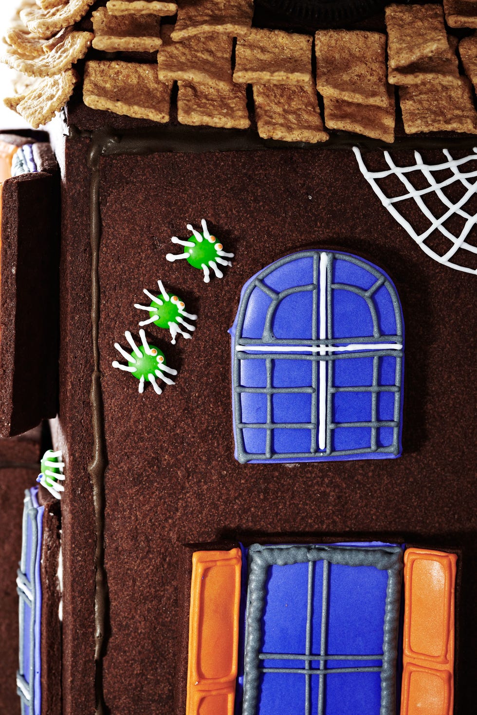 <p>Affix mini M&M's to the walls using royal icing. Then pipe royal icing legs and eyes and draw a web.</p>