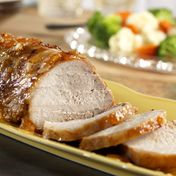 Pork roast slow-cooks to tenderness under a tangy glaze of apricot preserves, mustard, and onion yielding succulent results.
