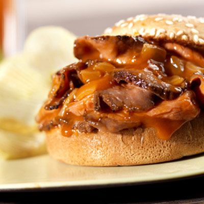 Deli roast beef simmers in a tangy tomato sauce and is served on toasted hamburger buns to make tasty, family-pleasing sandwiches.