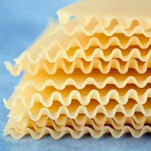 Lasagna "<p>According to <i>The Silver Spoon Pasta</i>, this type of flat, wide egg noodle was popular with the Greeks as early as the first millennium BC. Often found with ruffled edges, lasagna noodles come in boil and no-boil varieties and are traditionally served layered with tomato sauce, meat, and bèchamel sauce and then baked, as in the classic <a href=""/recipefinder/traditional-lasagna-bolognese-recipe"">Lasagna Bolognese</a>, but the filling possibilites are endless.</p><br />
<p><a href=""/search/fast_search_recipes?search_term=lasagna""><b>Find recipes for lasagna</b></a></p>"