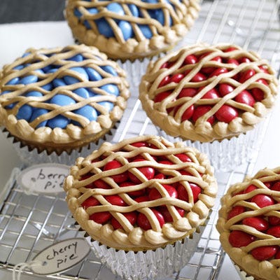 <p>Our berry pie cupcakes are as easy as...pie! The blueberry and cherry filling is blue or red candies, and the frosting is tinted to look like a lattice crust. At your next bake sale, cover the table with these mini pastries, and we promise you will sell out!</p><br /><p><b>Recipe:</b> <a href="/recipefinder/bake-sale-pie-cupcakes-recipe-opr0710" target="_blank"><b>Bake-Sale Pie Cupcakes</b></a></p>
