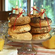 Have an early-morning birthday celebration with bagels or plain doughnuts instead of sugary cupcakes. Stack bagels atop a cake plate and place taper candles within each stack. Alternating pumpernickel and egg bagels or sesame and poppy can create colorful patterns. To ensure that the candles stay upright and don't lean on the bagels or doughnuts, drip some melted wax on the plate to use as an anchor. Festive ribbons add the final touch; just be sure to blow out the flames before they get too close!