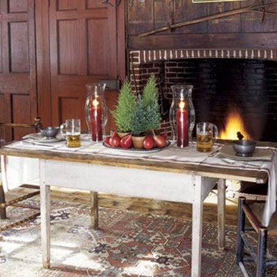 <p>It doesn't take more than a few touches of red and green deftly applied throughout the house to establish a festive air. The key to this classic approach: Be consistent with both your palette and your materials. Here, red pears surround a trio of miniature firs and are framed by two cranberry red candles.</p>