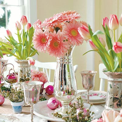 <p>Gerber daisies set in a voluptuous mercury-glass achieve a wonderfully rich effect. A collection of vintage ornaments inspired the tabletop palette.</p>