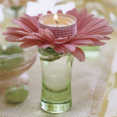Here's the votive's version of Easter finery: these enchanting assemblages, crafted in seconds and guaranteed to dress up any holiday table. All you need are candles, ribbon, gerbera daisies, cordial glasses, and double-stick tape. Affix a length of ribbon around the metal rim of the votive. Snip off almost the entire stem of the flower, splay out the petals, and insert into the glass. Top each daisy with a lit candle. For a twinkling effect, place a glass at each setting.