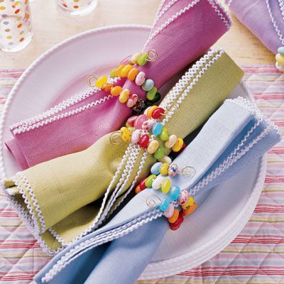 To make these unique napkin rings, thread small, brightly colored jelly beans on 22-gauge tin wire, long enough to wrap around a rolled napkin twice. Curl ends into swirls to keep candy in place.