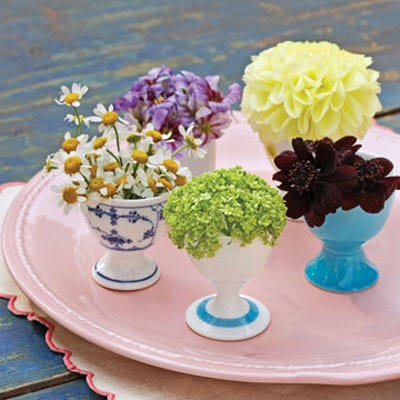 Don't toss broken flowers too small to fit in traditional-size vases. Gather a bunch of these tiny florets and place in small containers, such as egg cups. Let guests help themselves as they leave the party.