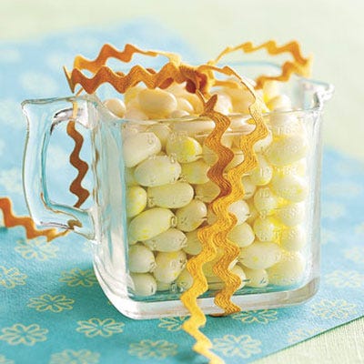 Try giving favors that guests can really use. Start with a flea market measuring cup, fill with candy, and tie with decorative ribbon.