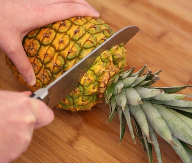 <p>Lay the pineapple on its side and cut the top.</p>