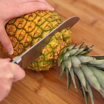 <p>Lay the pineapple on its side and cut the top.</p>