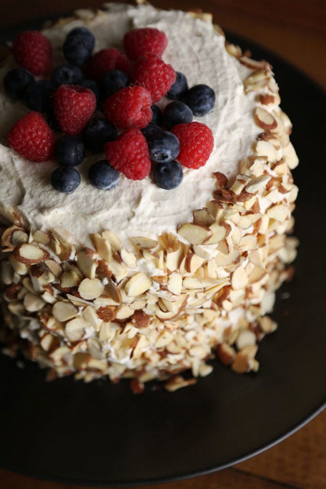 Take a heaping handful of mixed berries, and carefully drop them onto the top of the cake.