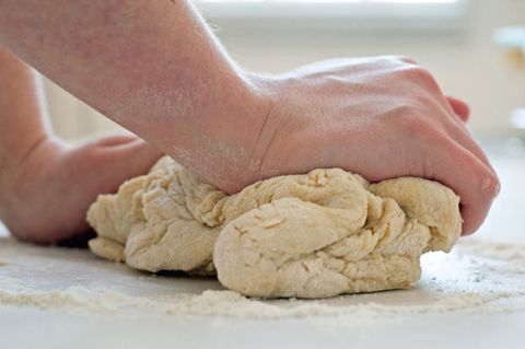 <p>Knead the dough on a lightly floured surface until it's smooth and elastic. If the dough appears very dry and won't come together, add water one tablespoon at a time. If it's too soft, add flour one tablespoon at a time.</p>