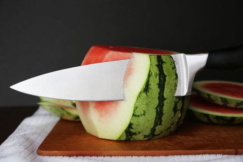 Slice the top and bottom of a mini seedless watermelon. Set it on a flat bottom. Slice the rind off the sides. Once the watermelon is prepped, pat it dry with paper towels, and transfer it to a plate to decorate.