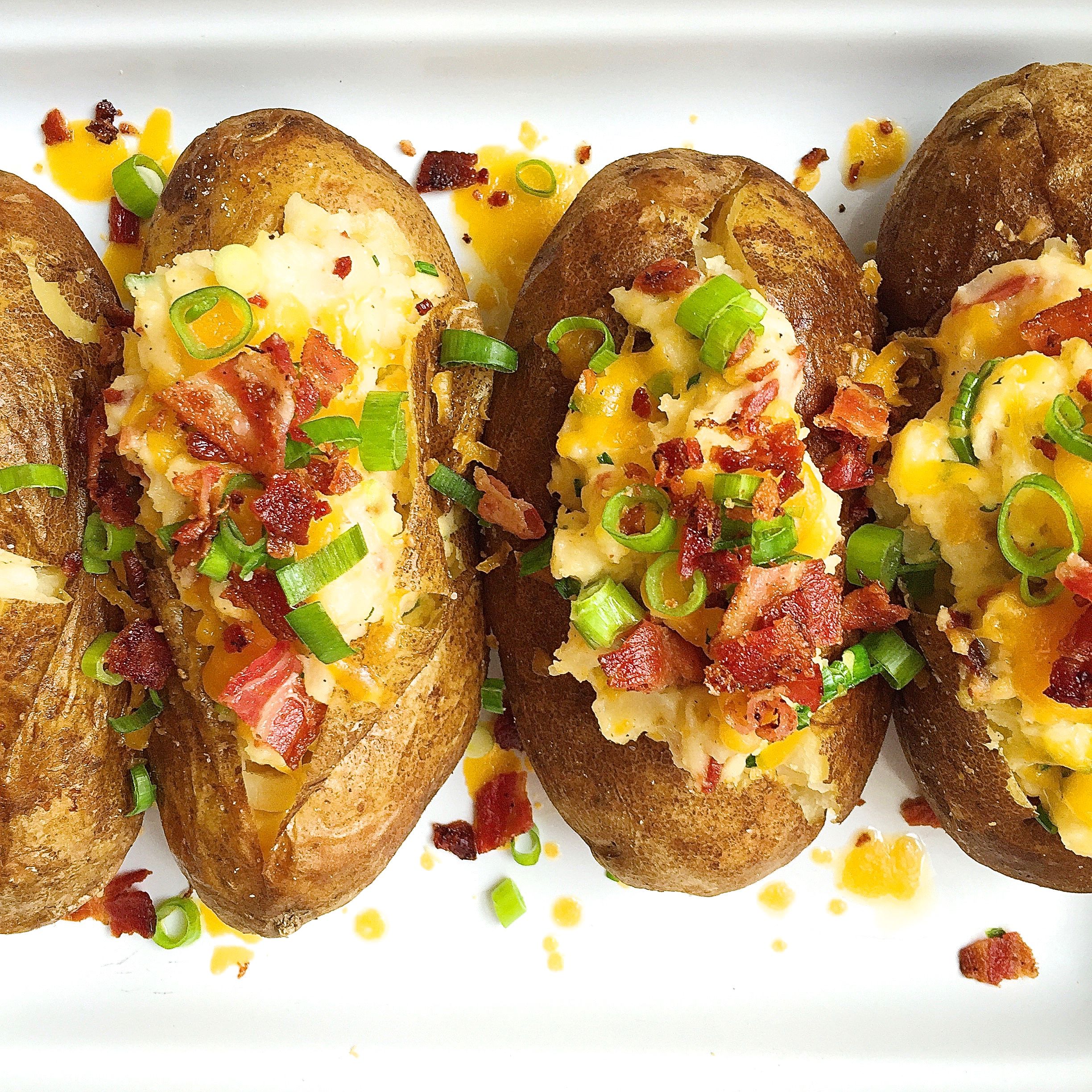 Best Loaded Baked Potatoes With Bacon And Cheddar Recipe How To Make Loaded Baked Potatoes With Bacon And Cheddar Delish Com