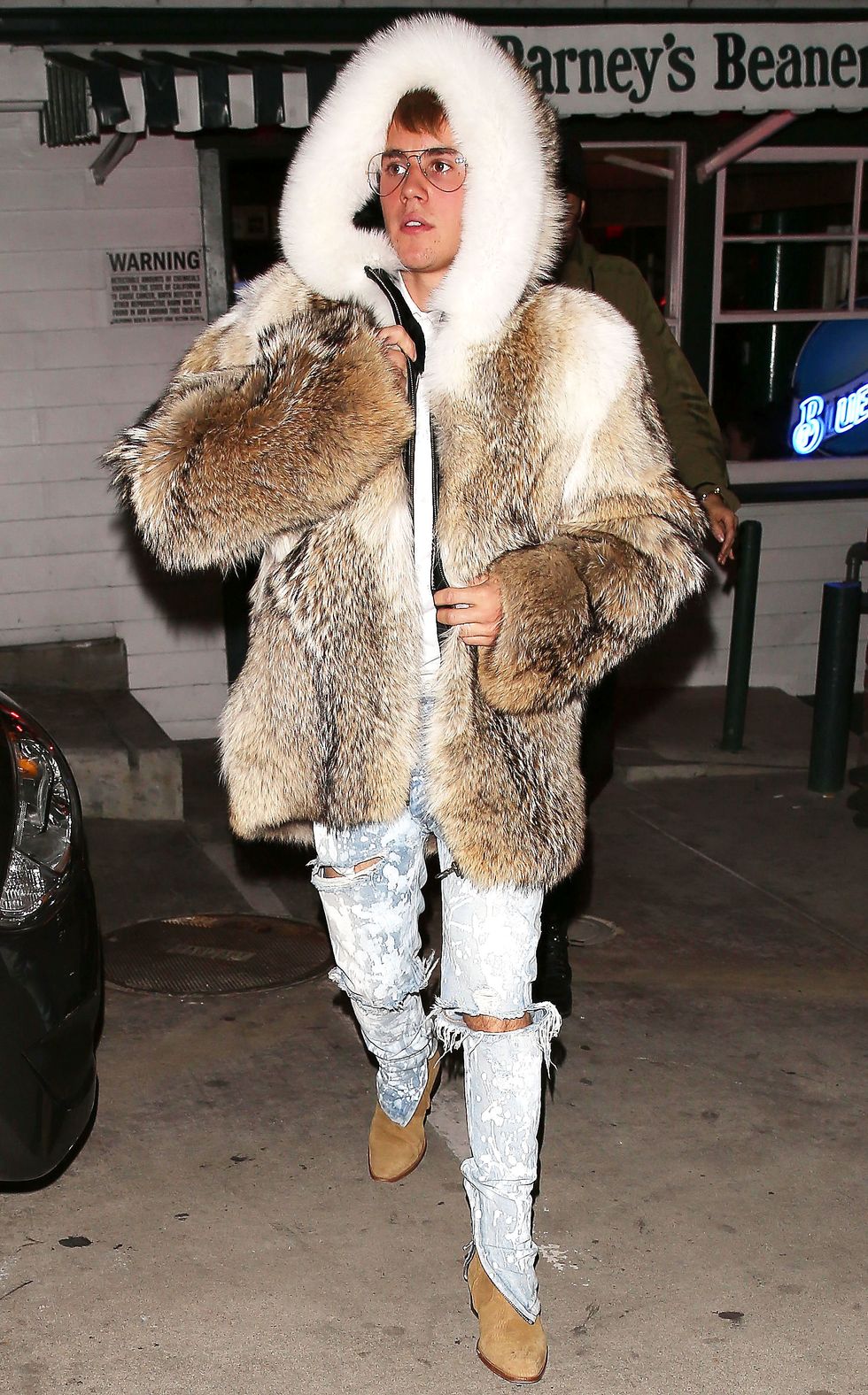 Justin Bieber steps out in a ridiculous fur coat with a huge candy cane and  angers animal rights groups