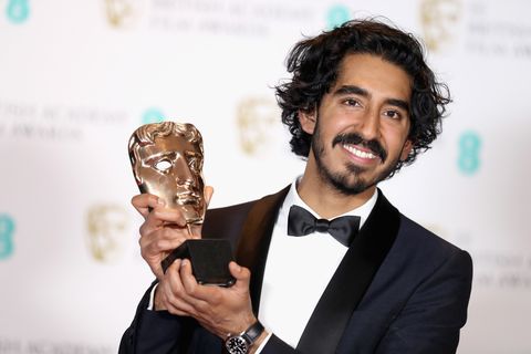 Dev Patel posing with his award at 70th BAFTAs