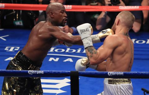 Floyd Mayweather Jr. throws a punch at Conor McGregor during their super welterweight boxing match on August 26, 2017