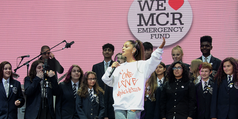 Ariana Grande performs on stage with Parrs Wood High School Choir during the One Love Manchester