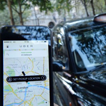 Uber app on smartphone, black taxi, London