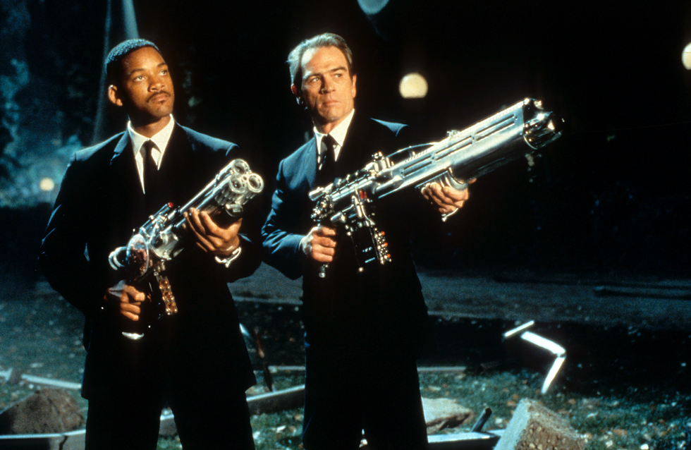 Will Smith and Tommy Lee Jones aiming their weapons towards the sky in a scene from the film 'Men In Black
