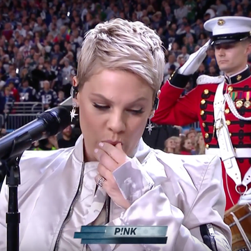 Pink taking something out of her mouth at the Super Bowl