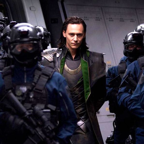 Loki (Tom Hiddleston) escorted by SHIELD agents