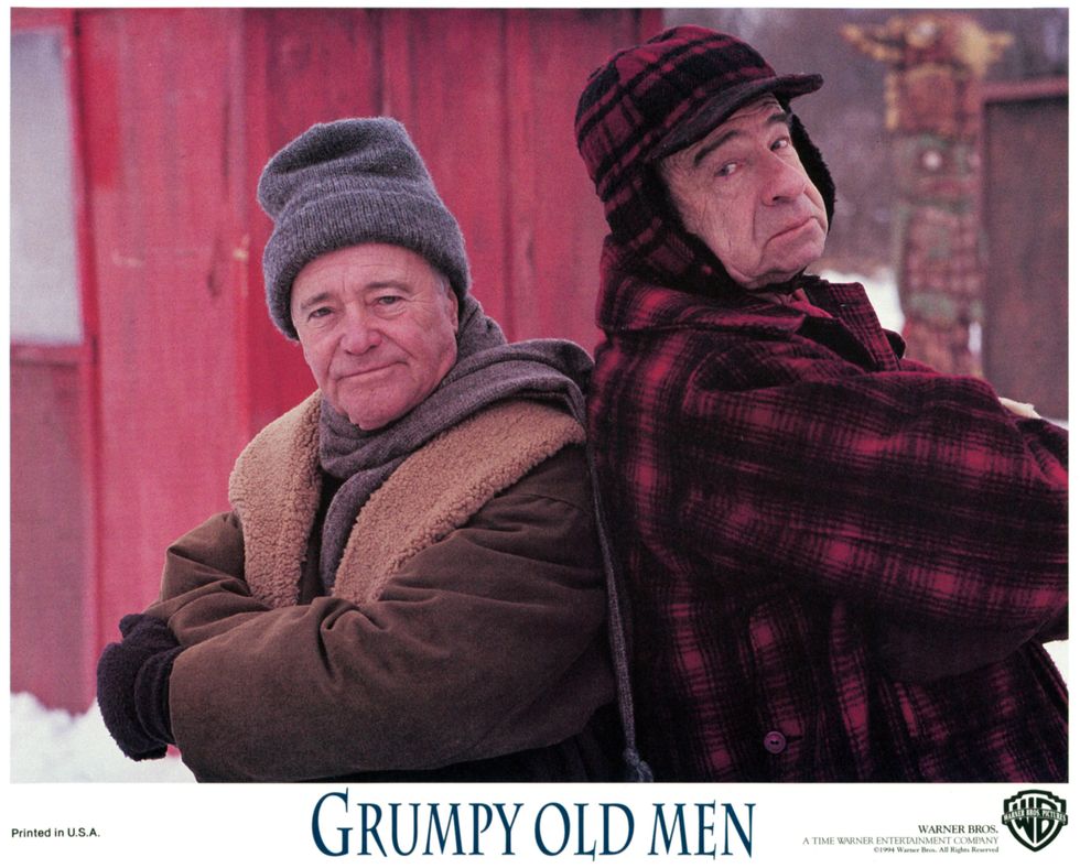 Jack Lemmon and Walter Matthau standing back to back outside in the snow in a scene from the film 'Grumpy Old Men', 1993