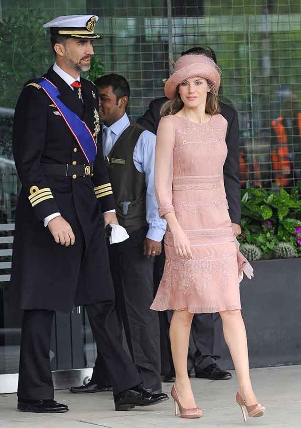Leg, Collar, Standing, Hat, Formal wear, Coat, Suit trousers, Cap, Uniform, Interaction, 
