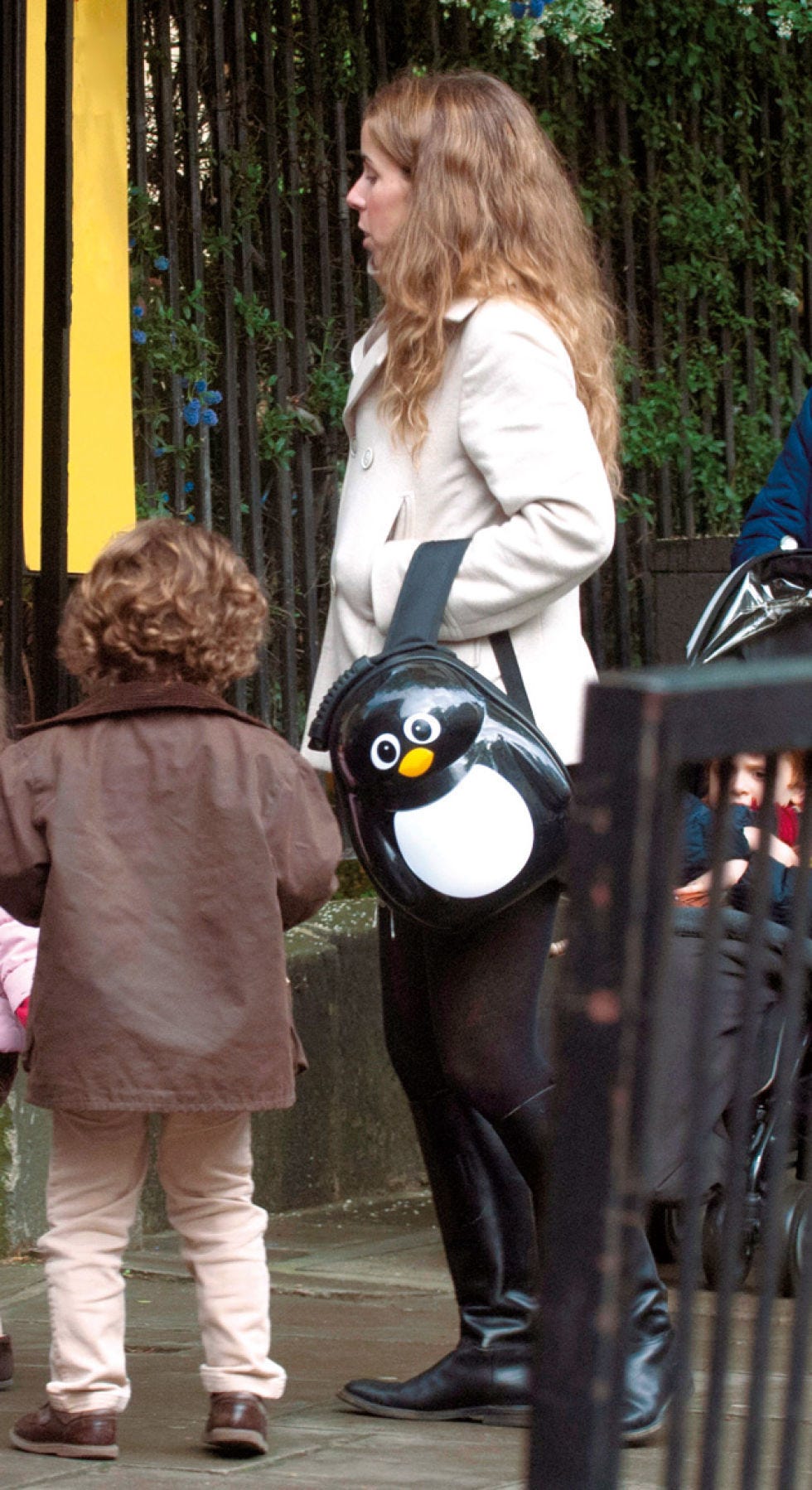 Penguin, Human, Beak, Flightless bird, Bird, Interaction, Street fashion, Blond, Fence, Stuffed toy, 