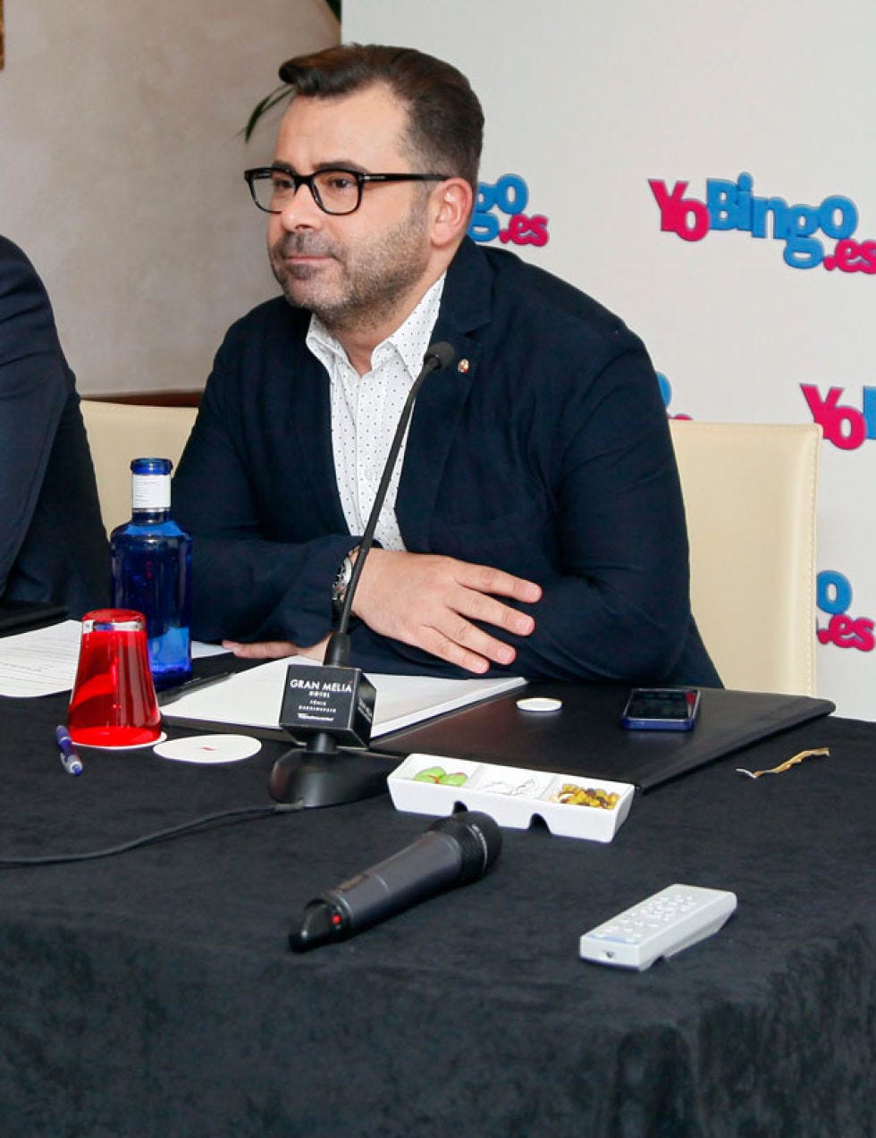Glasses, Table, Beard, Water bottle, Drinkware, Bottle, Plastic bottle, Facial hair, Pen, Mobile phone, 