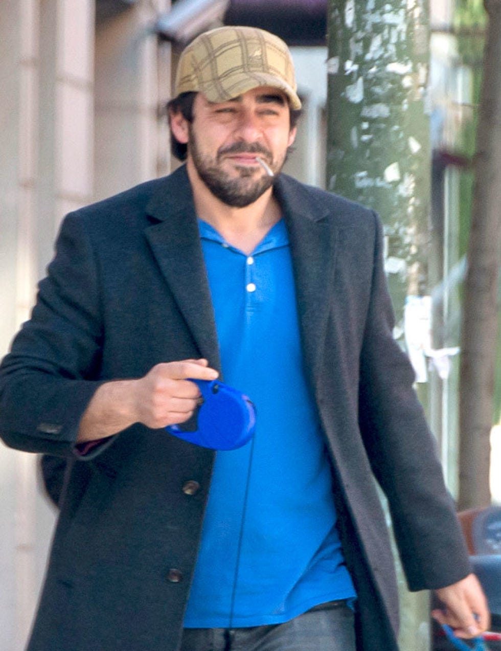 Clothing, Cap, Coat, Sleeve, Facial hair, Standing, Outerwear, Collar, Formal wear, Beard, 