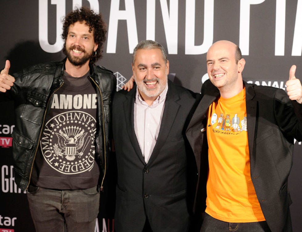Smile, Coat, Outerwear, Facial hair, Facial expression, Jacket, Suit, Logo, Beard, Thumb, 