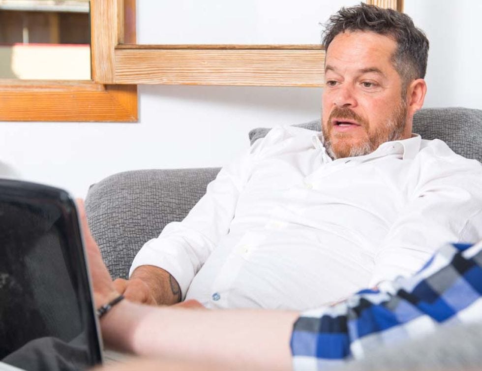 Comfort, Sitting, Electronic device, Dress shirt, Beard, Office equipment, Technology, Display device, Facial hair, Wrist, 