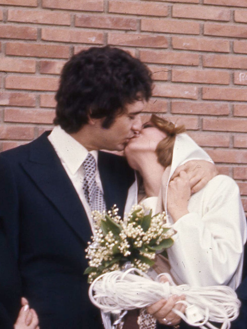 Coat, Brick, Photograph, Outerwear, Suit, Formal wear, Kiss, Romance, Interaction, Petal, 