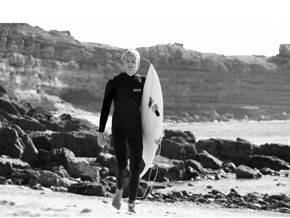 Human, Surfing Equipment, Surfboard, Standing, Surface water sports, Coastal and oceanic landforms, People in nature, Boardsport, Wetsuit, Shore, 