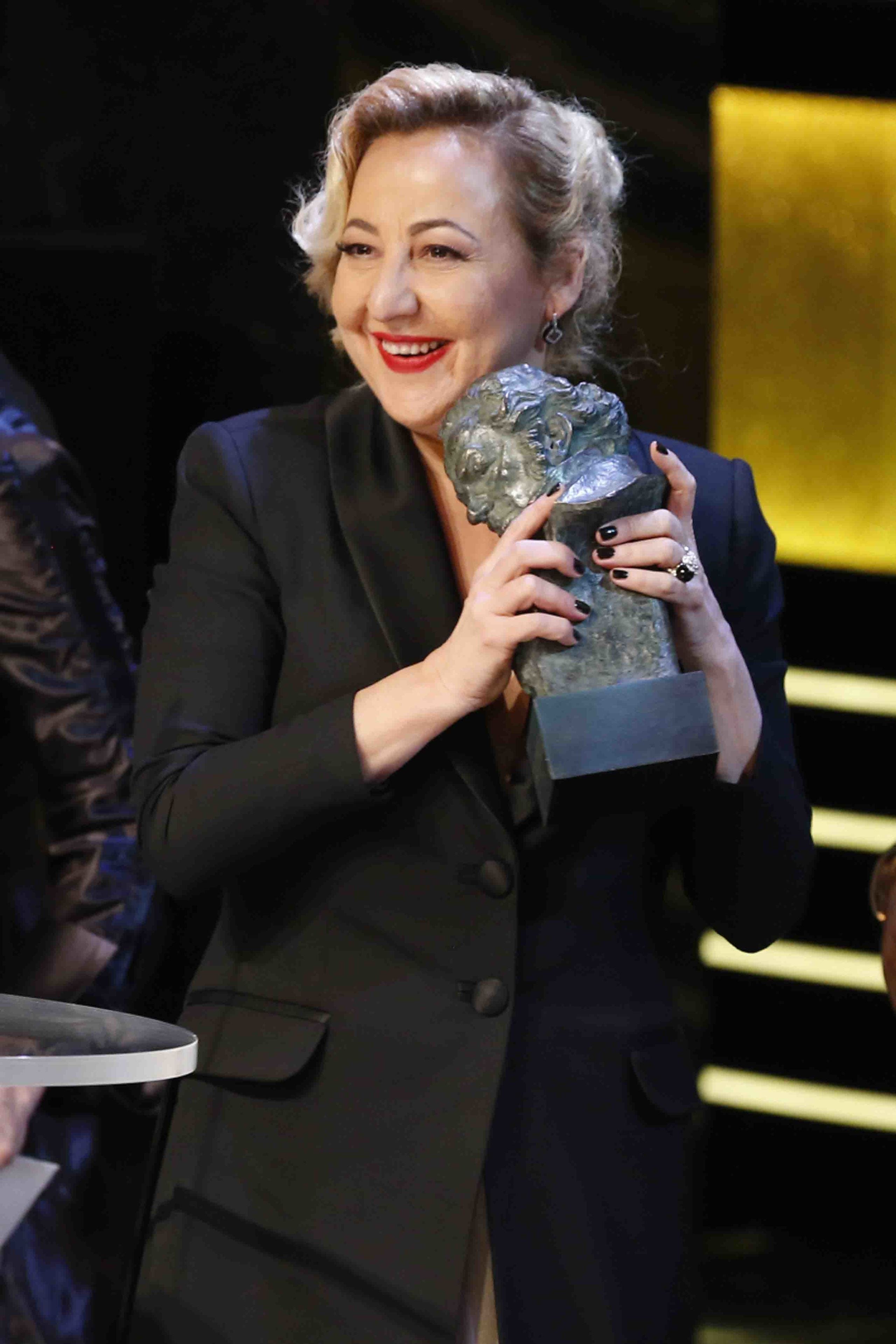 Microphone, Hand, Formal wear, Blazer, Pantsuit, Suit trousers, White-collar worker, Laugh, Pleased, Makeover, 