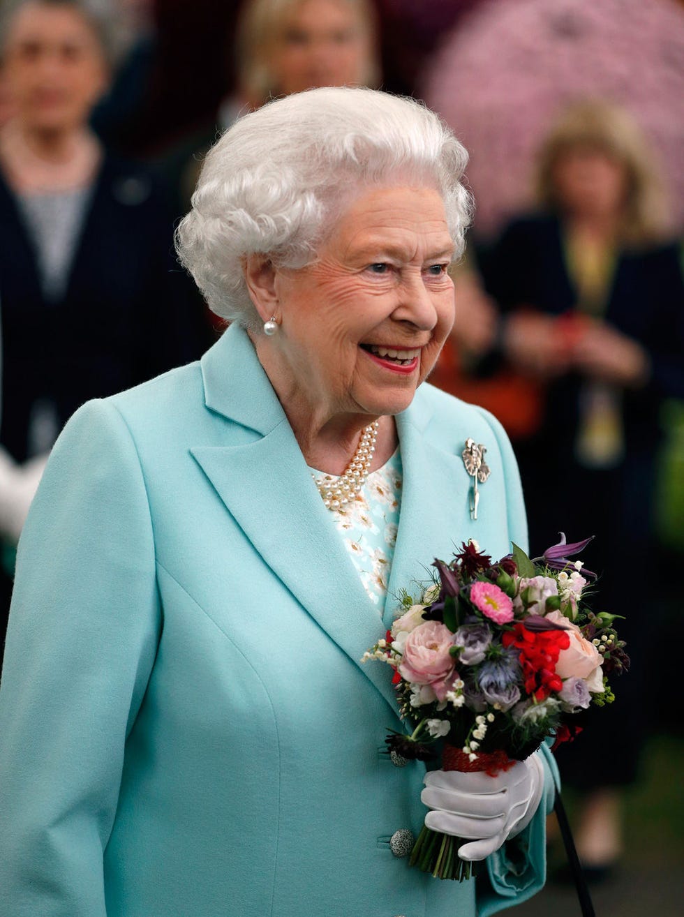 Outerwear, Coat, Facial expression, Jewellery, Bouquet, Blazer, Petal, Cut flowers, Wrinkle, Rose family, 