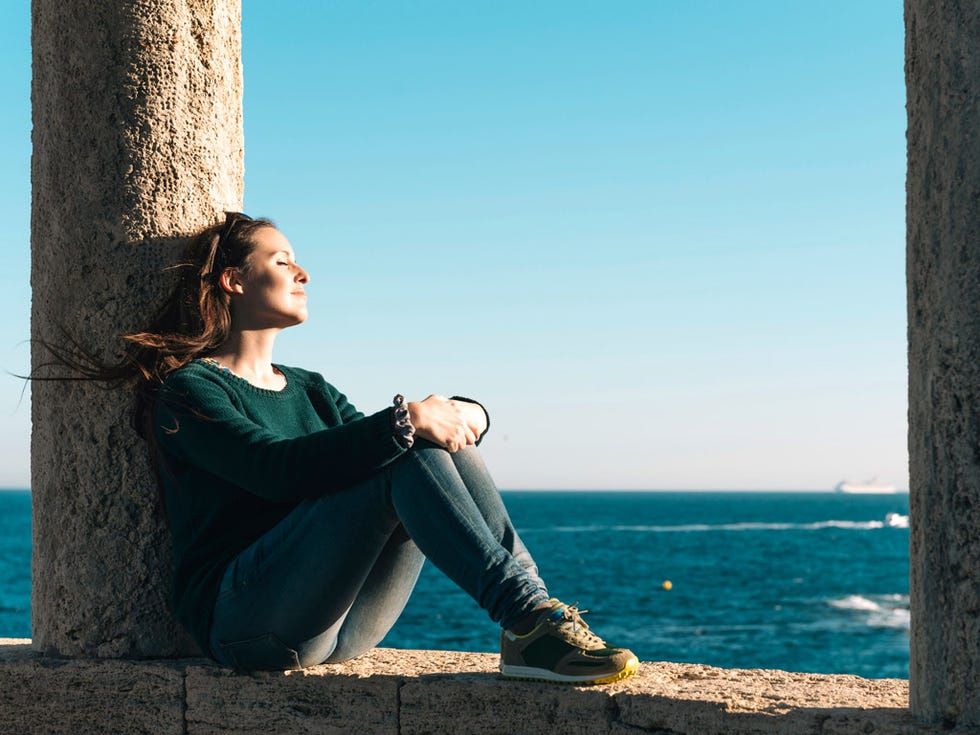 Jeans, Human leg, Denim, Sitting, Coastal and oceanic landforms, People in nature, Elbow, Knee, Azure, Ocean, 