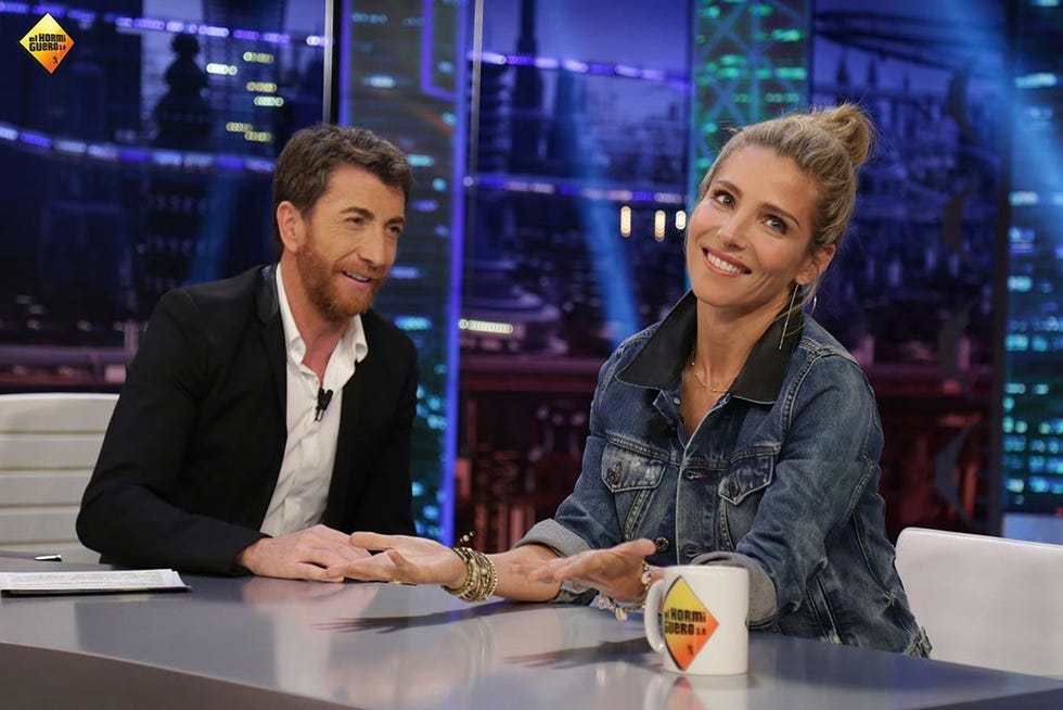 Smile, Table, Logo, Drinkware, White-collar worker, Employment, Television presenter, Conversation, Tie, Television program, 
