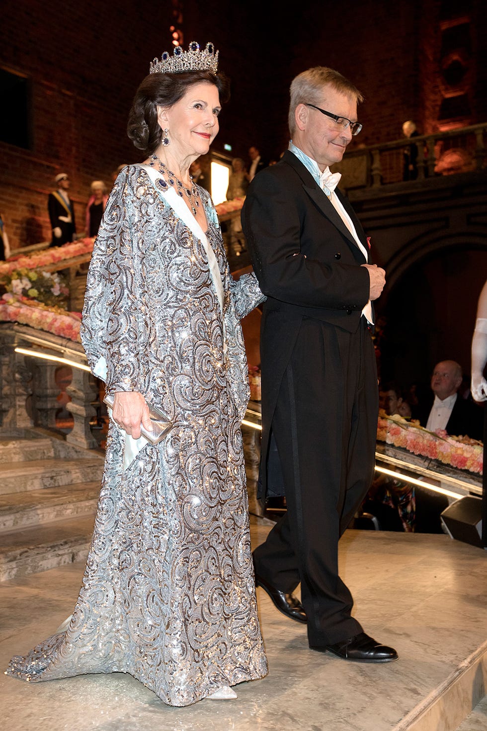 Outerwear, Coat, Suit, Formal wear, Dress, Fashion, Headpiece, Hair accessory, Tiara, Suit trousers, 