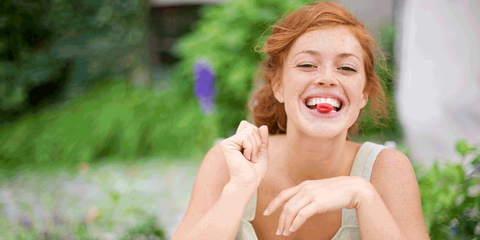 mujer joven comiendo frambuesas