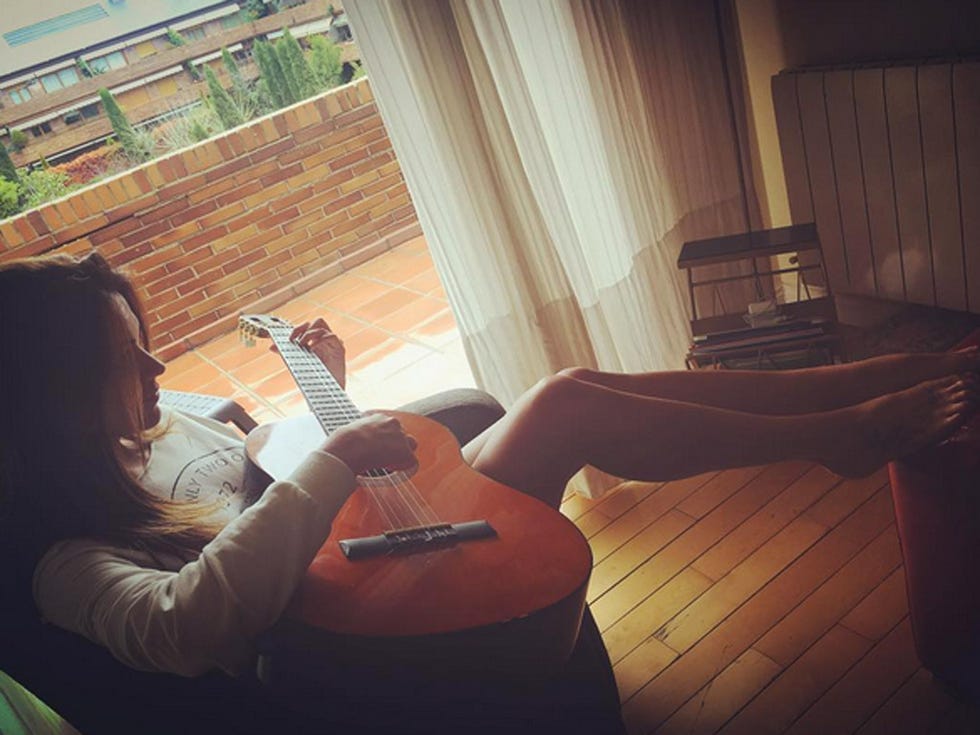 Comfort, Sitting, Window covering, Tints and shades, Sunlight, Window treatment, Curtain, Guitar, Lap, Lamp, 