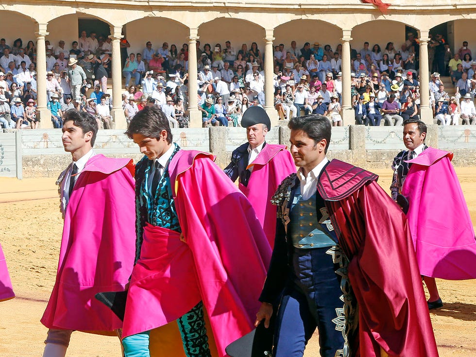 Matador, Tradition, Bullfighting, Event, Outerwear, Magenta, Performance, Sport venue, Temple, Cope, 