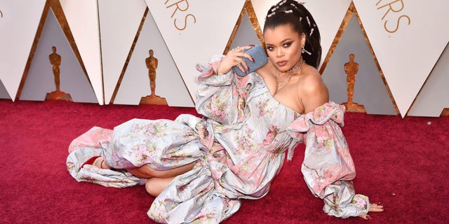 Hairstyle, Sitting, Black hair, Carpet, Smile, Flooring, Costume, 