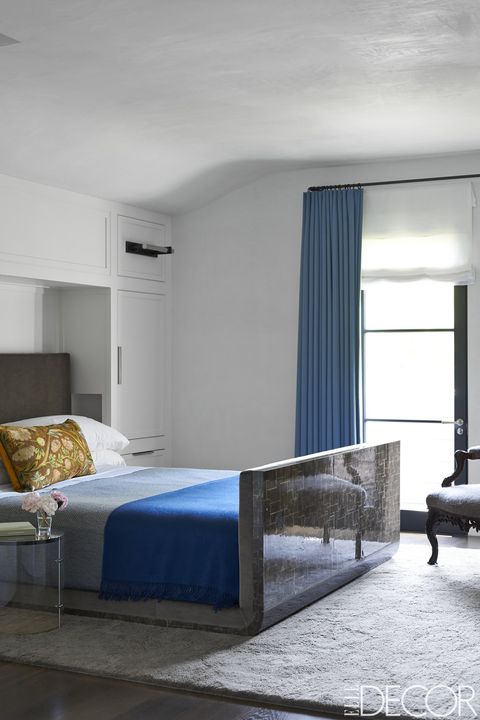 The bed in the master bedroom was designed by Maine Design, the sheets and blanket are by Deborah Sharpe Linens, and the pillow is covered in an 18th-century embroidered silk; the curtains are of a wool by Sandra Jordan, and the rug is by Mark Nelson.