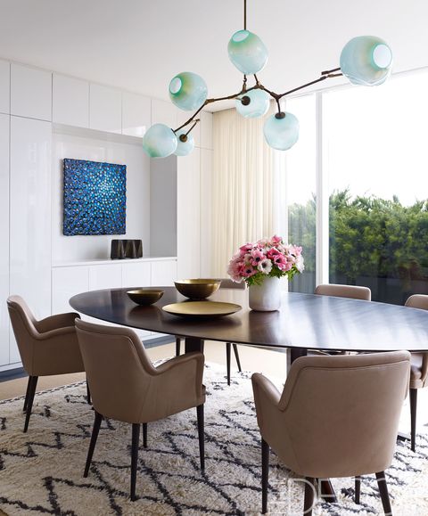 <p>A set of 1954 chairs by Osvaldo Borsani surrounds the custom-made dining table; the light fixture is by Lindsey Adelman, and the painting is by Robert Melee.</p>