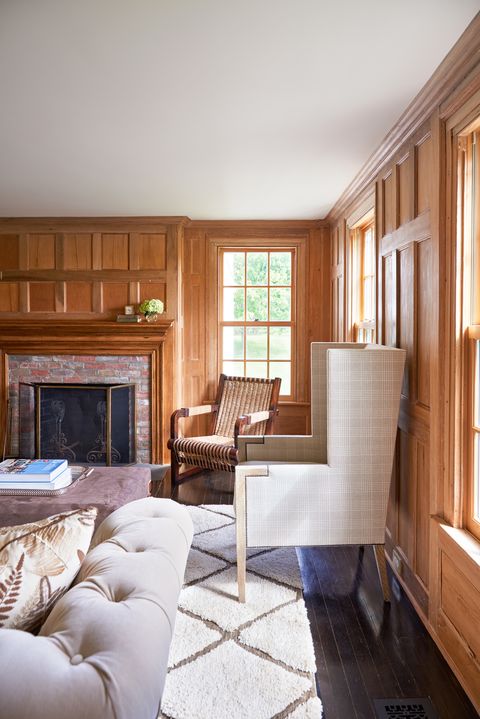 Wood paneling in the media room is original to the house; wingback chairs from Holly Hunt offer a cozy perch for family movie nights.