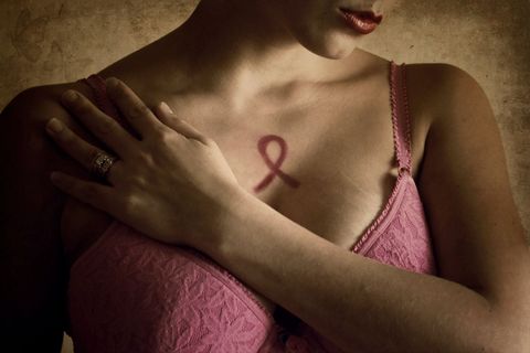 Woman in pink bra with pink breast cancer ribbon