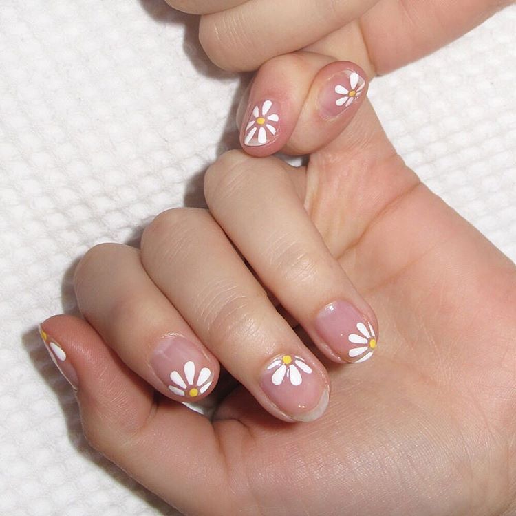 <p>Negative nails don't always have to be a geometric design. Start with a clear base coat. Using a thin brush, apply one yellow dot to each nail in a sporadic fashion. Clean off your brush and use it to paint white petals. Finish with a topcoat. </p><p>Design by <a href="https://www.instagram.com/p/BGsYV40iLq4/" target="_blank">@nataliepavloskinails</a></p>