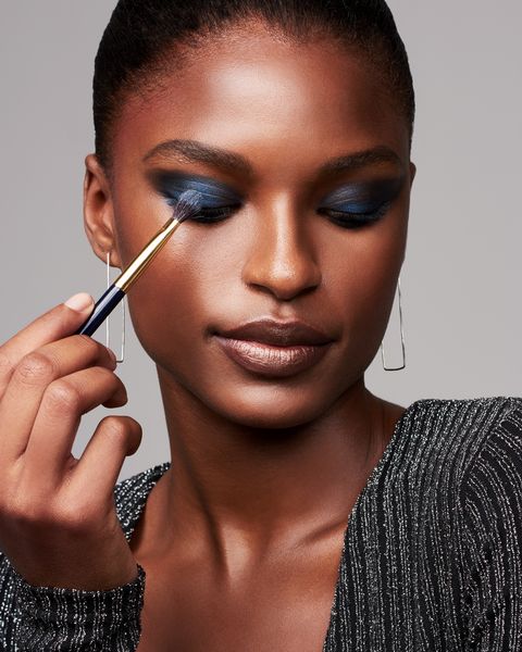 <p>Start by applying deep blue eyeshadow with a damp synthetic brush; tap the color across lids and into the creases. To wing the corners, add a dry layer with a fluffy brush and blend out toward your brow, following the angle of your lower lash line. Use the darker color as a lower liner as well. "Sharp edges are too much," warns Melluso. "Soft and effortless is more modern." The hue takes on a gleaming metallic finish with a dry mix of silver and light blue on top, plus silver on inner corners.</p>
